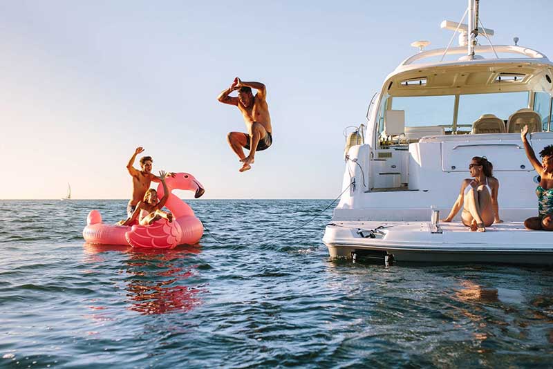 Family enjoting a swim off the bow of their private yacht