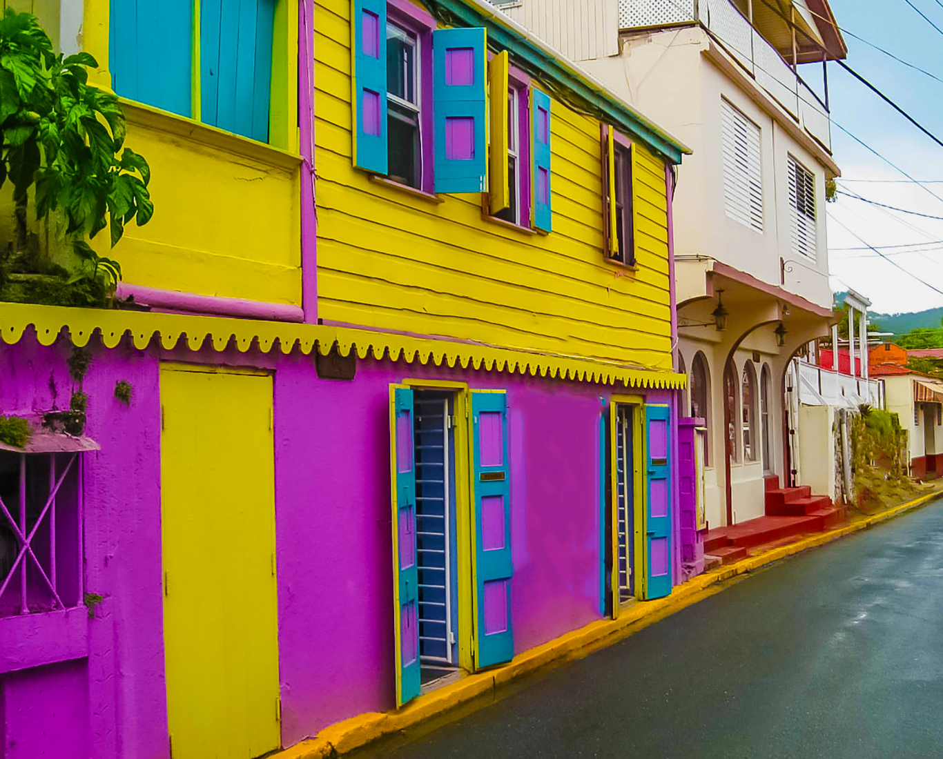 a building brightly painted yellow purple and teal